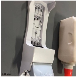 A Floormat Hand Soap Dispenser is attached to a wall.