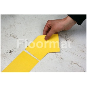 A person cutting a piece of yellow paper with 45 Degree Corners Pallet Floor Markers.