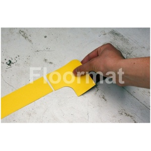 A person cutting a yellow tape on a white floor marked with 90 Degree Corners Pallet Floor Markers.