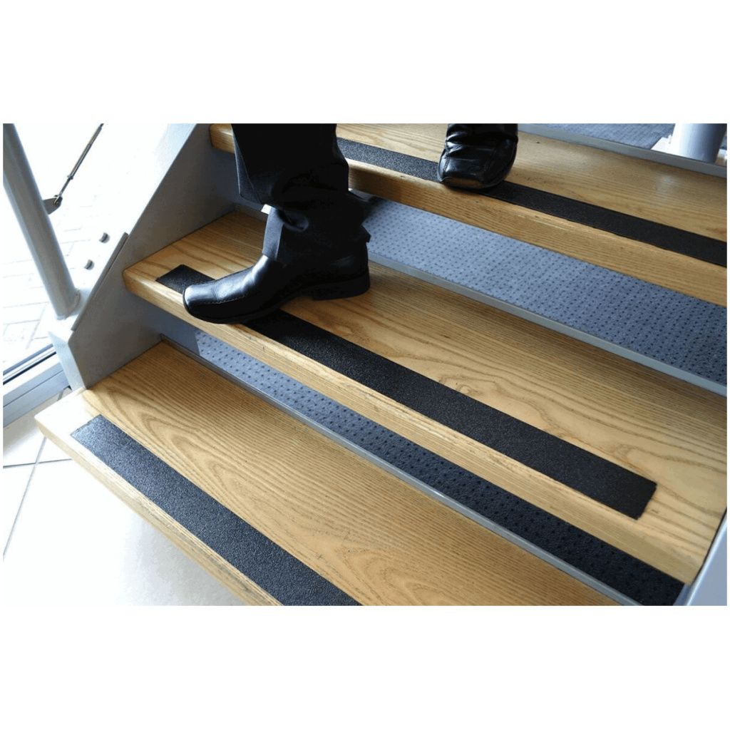 A person is standing on a wooden stair tread.