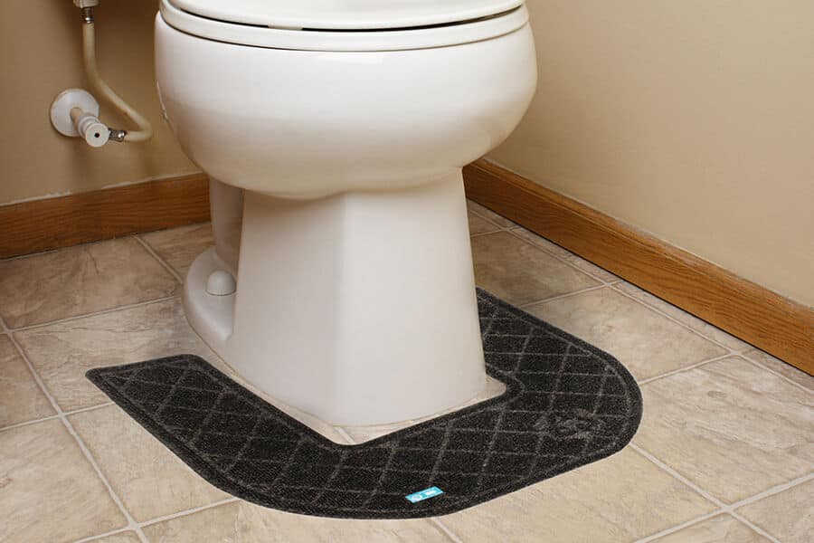 A bathroom with a CleanShield™ Commode Mat on the floor.