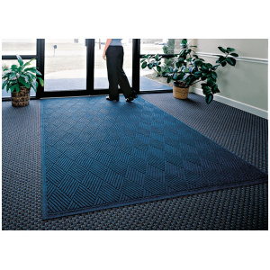 A woman posing with a WaterHog Fashion Diamond Floor Mat.