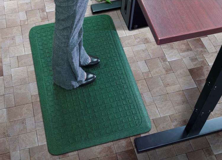 A person using the Get Fit Stand Up Anti-Fatigue Floor Mat while standing in front of a desk.
