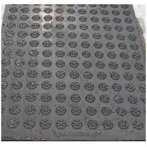 A black HOTFlake Walkway / Driveway Mat with a pattern of flowers on it.