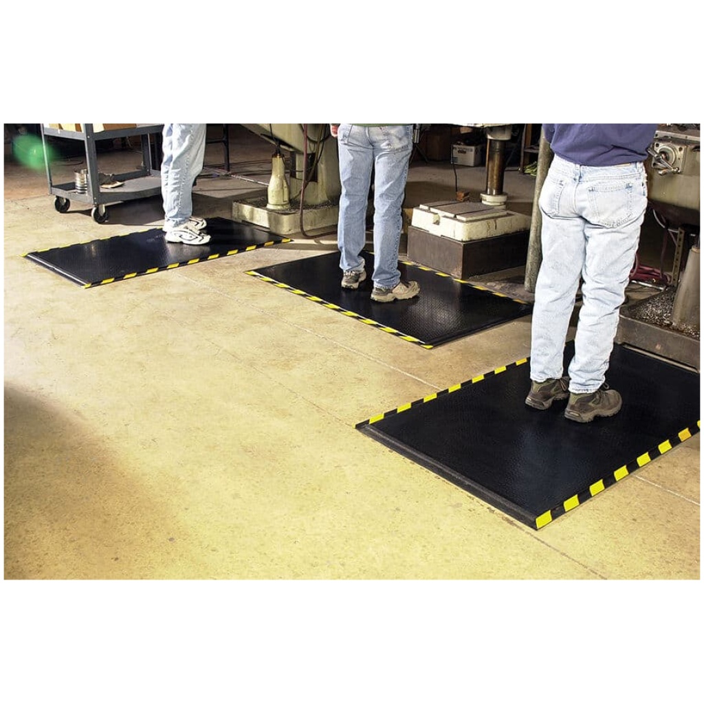 A group of people standing in front of a DuraComfort Grip Floor Mat for promotional purposes.