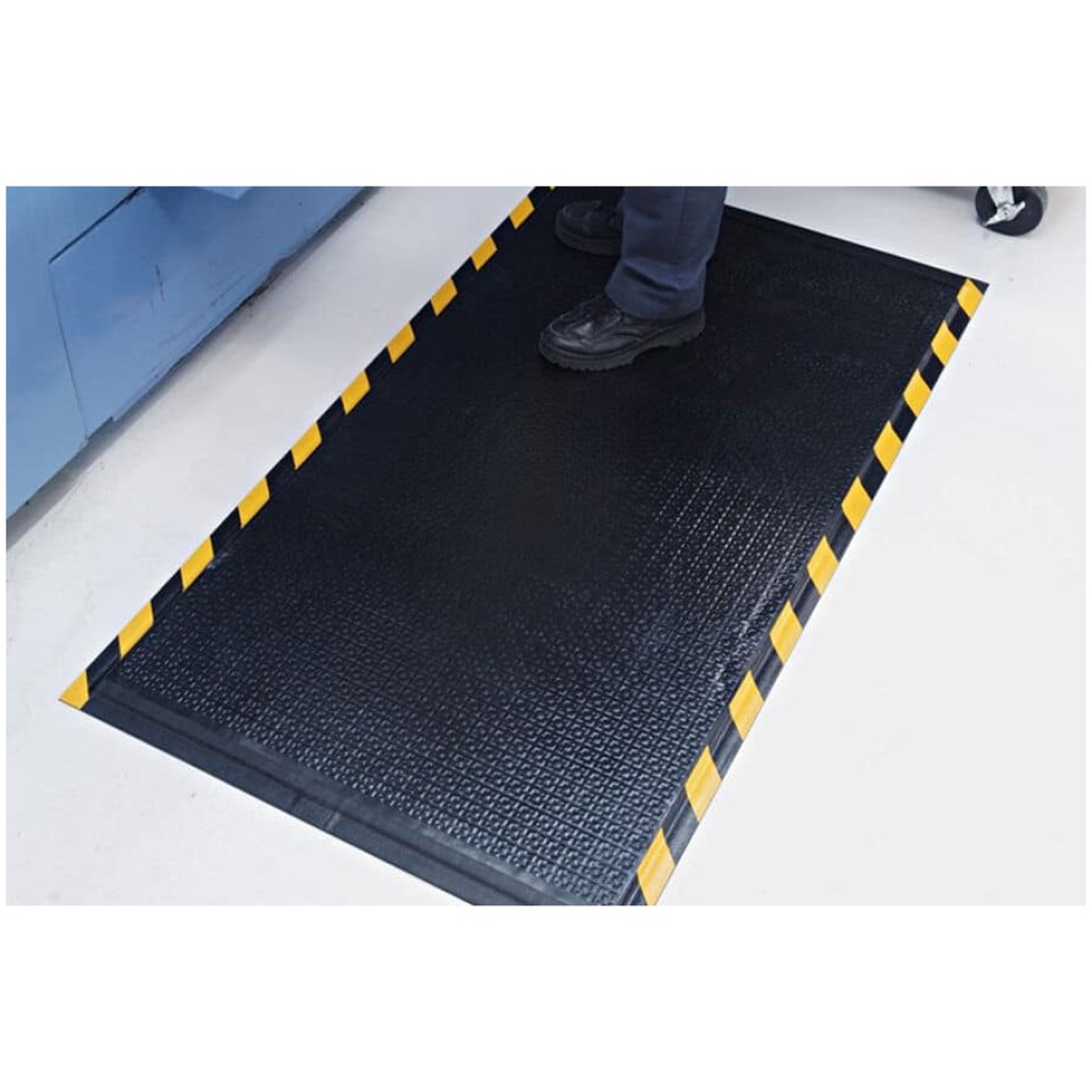 A person standing on a factory floor mat.