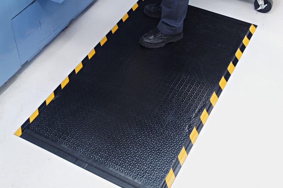 A person standing on a factory floor mat.