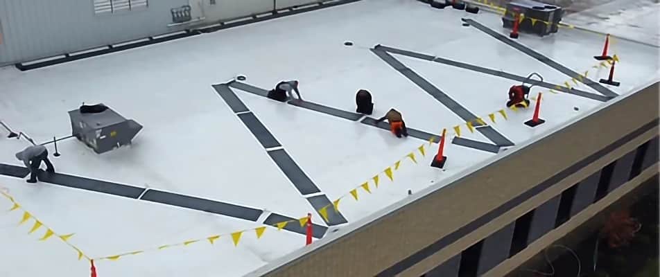 An aerial view of people working on a Commercial Heated Roof Mat System.