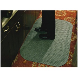 A person standing on a rug in a kitchen.