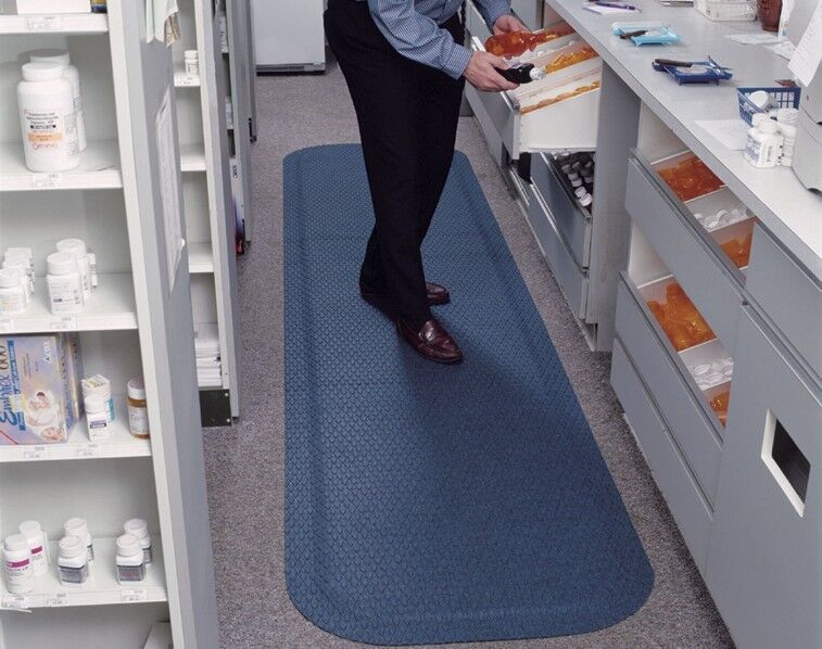 A man standing in a pharmacy with a blue floor mat.