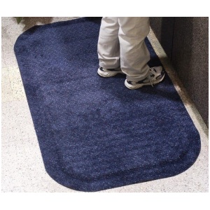 A person standing on a blue mat in a lobby.