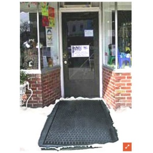 A black mat in front of a store with snow on it.
