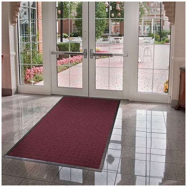 A Portrait Floor Mat in front of a glass door.