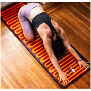 A woman practicing yoga on a heated floor mat.