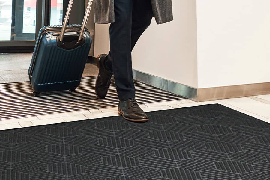 A man carrying WaterHog Silver Mat luggage.