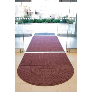 A door mat with a circular pattern in front of a glass door.
