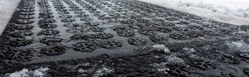 A black mat covered in snow and ice.