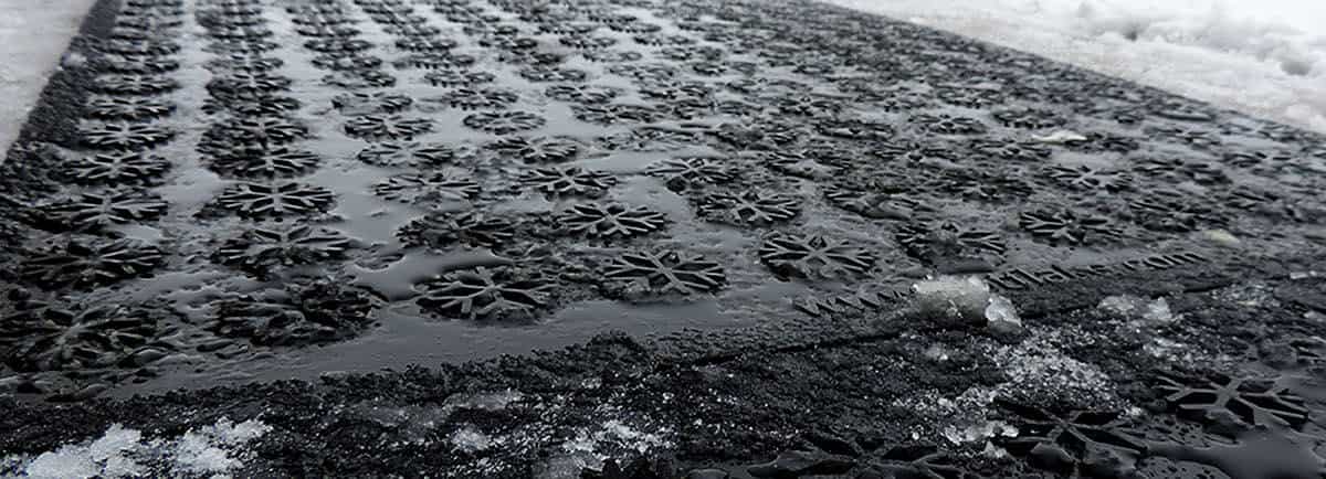 A black mat covered in snow and ice.