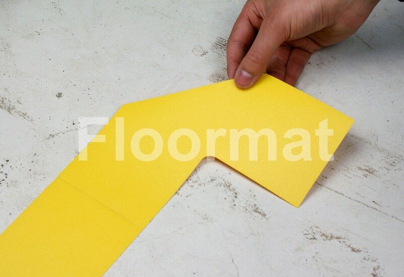 A person cutting a piece of yellow paper on Bridges Pallet Floor Markers.