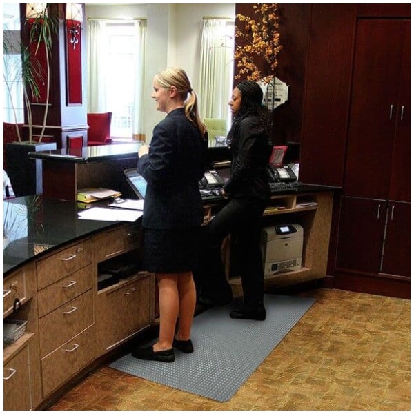 Two women standing in front of a counter on the Bubble Trax™ Anti-Fatigue Floor Mat.