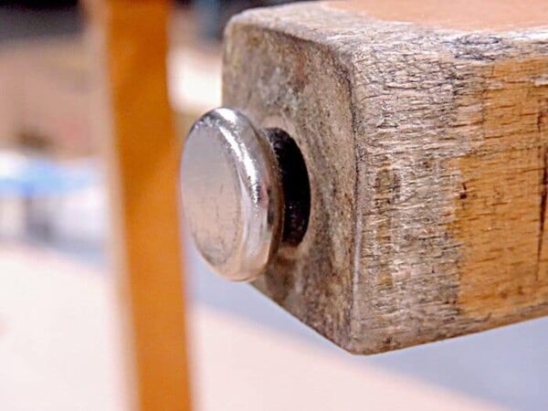 A close up of a metal button on a chair.