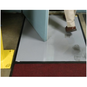 A man is walking into a doorway with a Clean Stride Dirt Removal Frame With Carpet mat.
