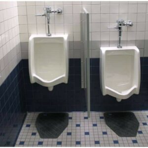Two white urinals on a tiled bathroom wall with one partition, each with a CleanShield™ Urinal Floor Mat.