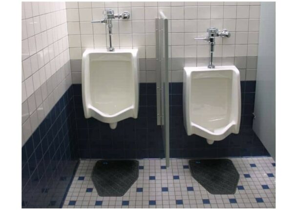 Two white urinals on a tiled bathroom wall with one partition, each with a CleanShield™ Urinal Floor Mat.