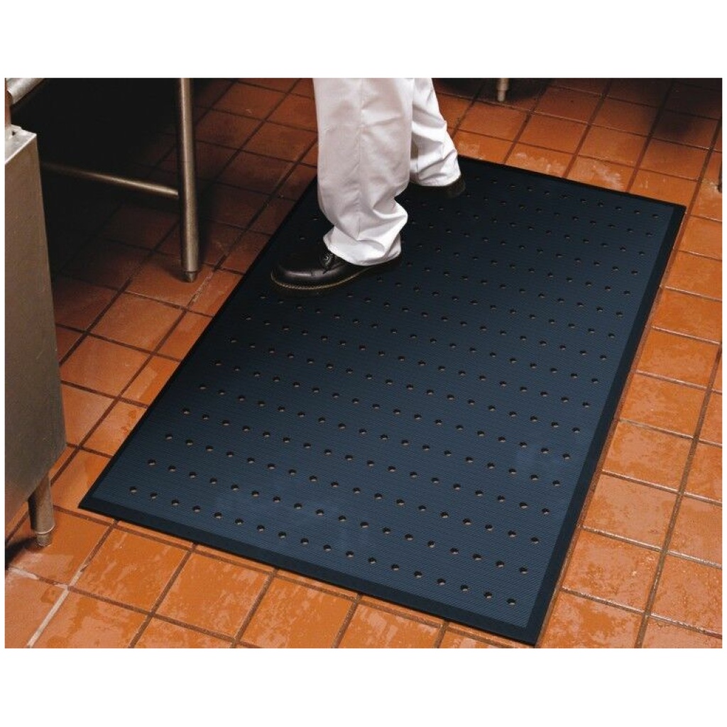 A person standing on a Complete Comfort Floor Mat in their kitchen.