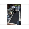 A woman standing in front of a bar on a Complete Comfort Floor Mat for complete comfort.