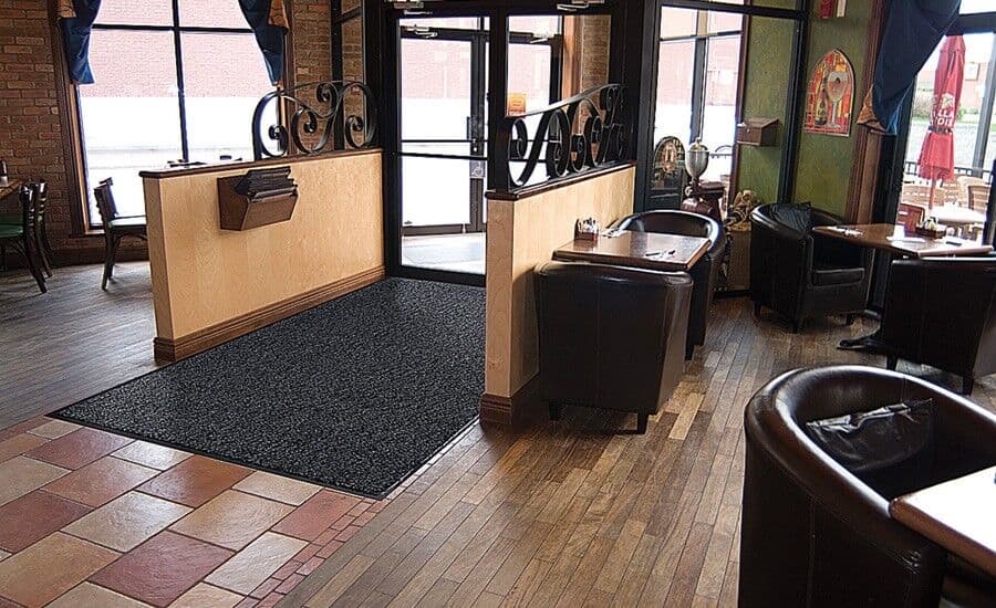 A restaurant with tables and chairs in front of a door.