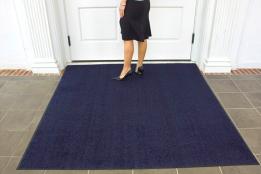 A woman in a black dress standing in front of a door.