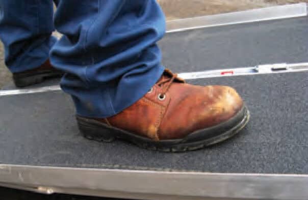 A person using Wooster Products Flex-Tred® Black Variable Coarseness Anti-Slip Tape.