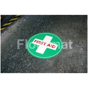 A First Aid Photoluminescent sign on a concrete floor.