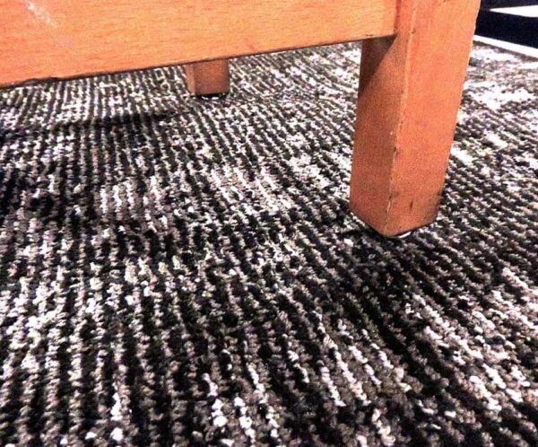 A close up of a Glide Chair on a black rug.