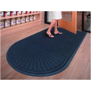 A woman is standing in front of a WaterHog Eco Grand Mat.