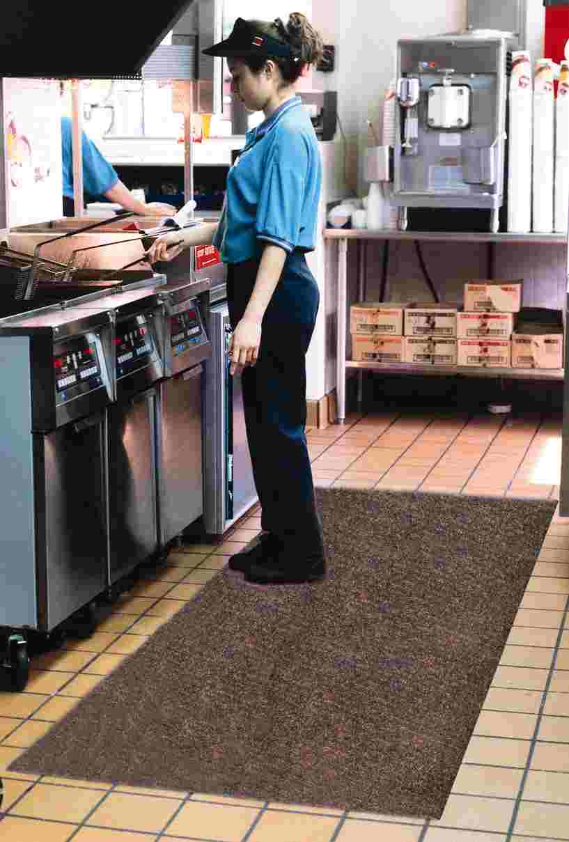 A woman is standing among kitchen mats.