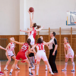 A group of girls playing basketball on floormats in a gym, prioritizing school safety.