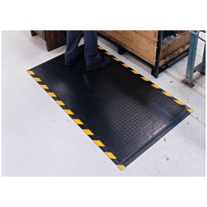 A person standing on a DuraComfort Textured Floor Mat in a warehouse.
