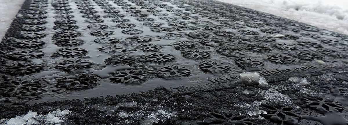 A black mat covered in snow and ice.