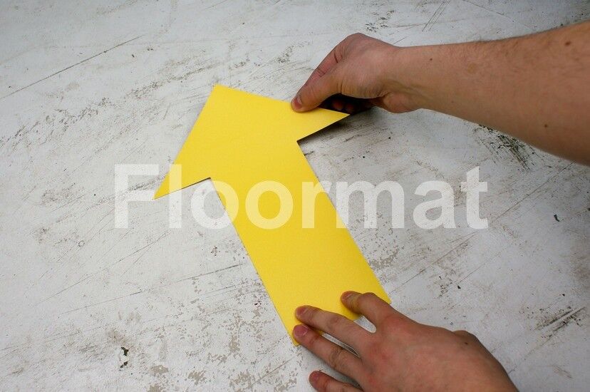 A person marking an Arrow Floor Markers on the floor.