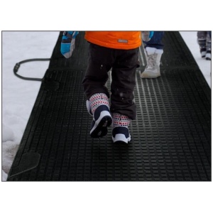 Two children walking on a Melt Step Snow Melting Mat in the snow before it starts to melt.