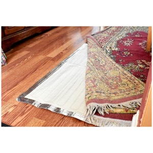 A RugBuddy heating panel is placed on a wooden floor.
