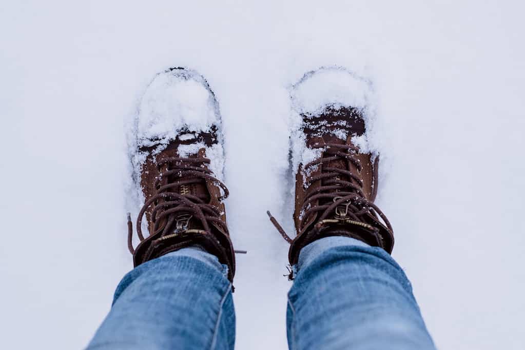 The feet of a person standing on snow.