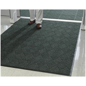 A man standing in front of a door with a WaterHog Eco Premier Fashion Floor Mat.