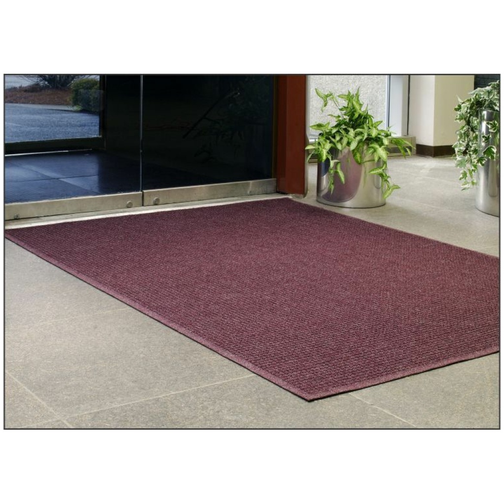 A burgundy door mat in front of a glass door.