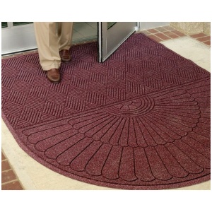 A person standing in front of a door with a WaterHog Eco Grand Mat.