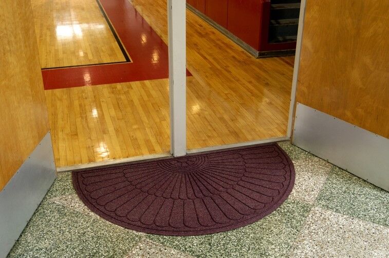 A WaterHog Eco Grand Mat placed in a hallway adjacent to a basketball court.
Product Name: WaterHog Eco Grand Mat