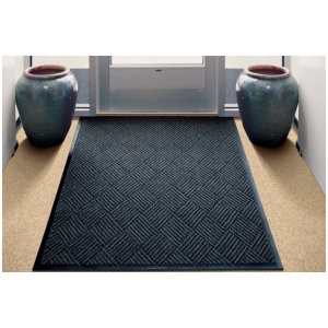 A Waterhog Diamondcord floor mat with a vase in front of it.