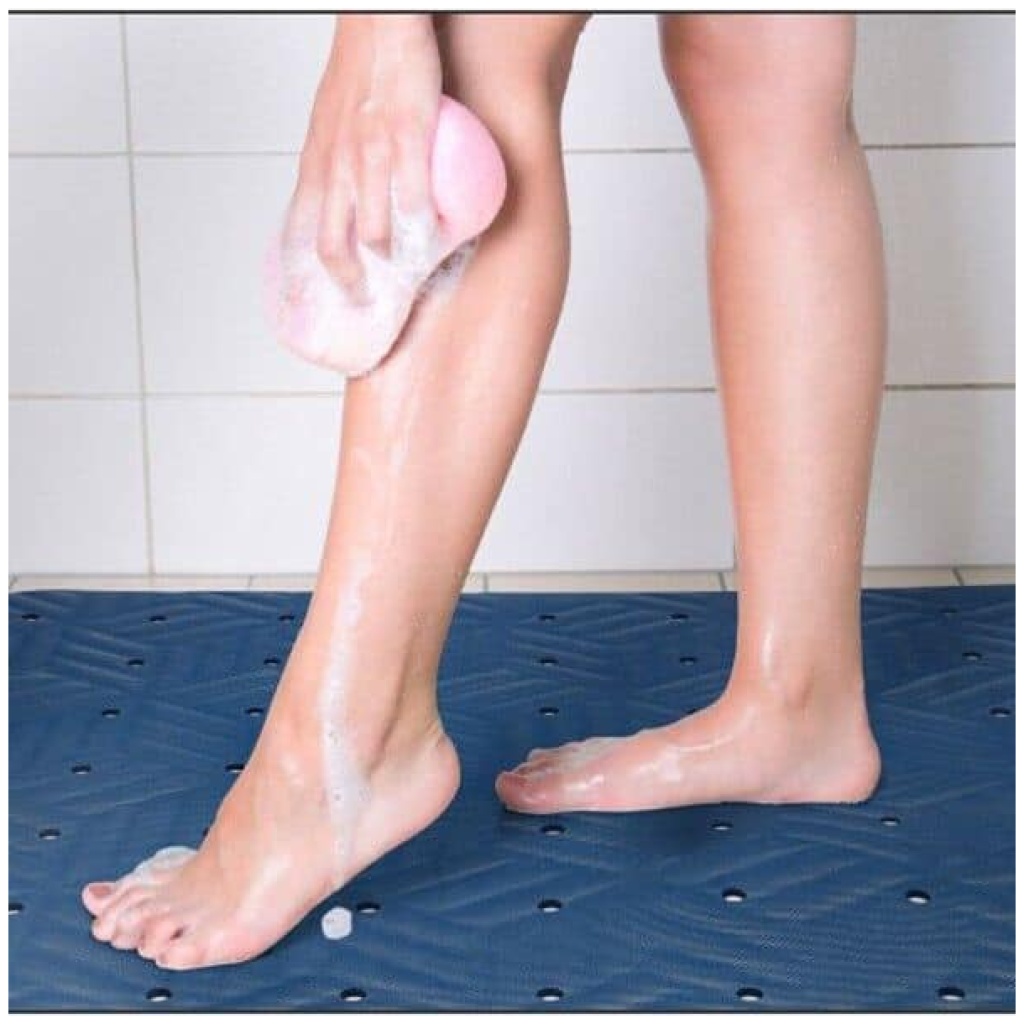 A woman is using a Wet Step Floor Mat to wash her feet.